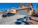 Inviting two-story home with a tile roof, attached garage, and a neatly maintained front yard with a long driveway at 8370 Lost Lake Ct, Las Vegas, NV 89147