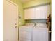 Bright laundry room equipped with washer, dryer, and overhead cabinets at 8370 Lost Lake Ct, Las Vegas, NV 89147