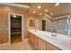Bright primary bathroom featuring a double sink vanity, large mirror, and a separate walk-in closet at 9923 Sierra Canyon Way, Las Vegas, NV 89147