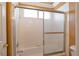 Bathroom featuring a bathtub-shower combo with sliding glass doors and tiled walls at 9923 Sierra Canyon Way, Las Vegas, NV 89147