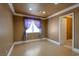 Bedroom with light-colored wood floors, featuring recessed lighting, a window with purple decorative curtains, and a door leading to the bathroom at 9923 Sierra Canyon Way, Las Vegas, NV 89147