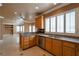 Kitchen with granite countertops and wood cabinets overlooking a bright, open-concept living area at 9923 Sierra Canyon Way, Las Vegas, NV 89147