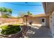 Backyard with a covered patio, fire pit area, lush lawn, and block wall at 100 Walker Way, Boulder City, NV 89005