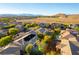 An elevated aerial view of a home in a neighborhood featuring a swimming pool and beautiful mountain views at 10002 Trapper Mountain St, Las Vegas, NV 89178