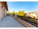 A spacious balcony features metal railings and views of neighborhood greenery and nearby home at 10002 Trapper Mountain St, Las Vegas, NV 89178