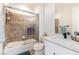 Bathroom featuring tiled shower-over-tub combination with glass door and white single sink vanity at 10002 Trapper Mountain St, Las Vegas, NV 89178