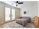 Bright bedroom features light-colored walls, stylish ceiling fan, a comfortable bed and light-filtering shutters on French doors at 10002 Trapper Mountain St, Las Vegas, NV 89178