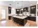 Modern kitchen features a large center island, stainless steel appliances, and sleek black cabinetry at 10002 Trapper Mountain St, Las Vegas, NV 89178