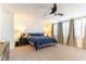 Spacious main bedroom with a plush bed, a modern ceiling fan, and large windows for natural light at 10002 Trapper Mountain St, Las Vegas, NV 89178