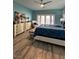 Bedroom with blue walls, ceiling fan, dresser, bench and a view to backyard at 1198 Golf Club, Laughlin, NV 89029
