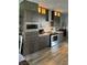Modern kitchen featuring stainless steel appliances, wood cabinetry, quartz countertops, and designer tile backsplash at 1198 Golf Club, Laughlin, NV 89029