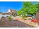 Large backyard featuring a covered patio, outdoor furniture, mature trees and decorative rock at 1213 High Altitude Ave, North Las Vegas, NV 89032