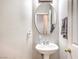 Compact bathroom with pedestal sink, oval mirror, and simple decor at 1213 High Altitude Ave, North Las Vegas, NV 89032