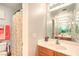 Bright bathroom featuring a single sink vanity, large mirror, and a shower with a floral curtain at 1213 High Altitude Ave, North Las Vegas, NV 89032