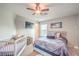 Cozy bedroom with a ceiling fan, carpet flooring, crib, and neutral colored walls at 1213 High Altitude Ave, North Las Vegas, NV 89032