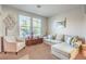 Comfortable living room features neutral tones, large windows, and stylish furnishings, creating a relaxing atmosphere at 1213 High Altitude Ave, North Las Vegas, NV 89032
