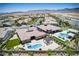 Wide angle aerial shot features neighborhood pools, patios, desert landscape, and mountain views at 12168 Dorada Coast Ave, Las Vegas, NV 89138