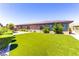 Spacious backyard with manicured shrubs and artificial turf extending to the edge of the property at 12168 Dorada Coast Ave, Las Vegas, NV 89138