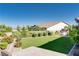 Private backyard with artificial lawn, mature trees, and manicured shrubs at 12168 Dorada Coast Ave, Las Vegas, NV 89138