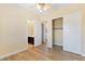 Bright bedroom featuring wood floors, a ceiling fan, and access to an ensuite bathroom with walk-in closet at 12168 Dorada Coast Ave, Las Vegas, NV 89138