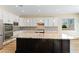 Kitchen with white cabinets, stainless steel appliances, granite counters and dark island at 12168 Dorada Coast Ave, Las Vegas, NV 89138