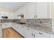 Elegant kitchen with white cabinets, stone countertops, and modern stainless steel appliances at 12168 Dorada Coast Ave, Las Vegas, NV 89138