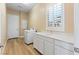 Laundry room with a front load washer, shaker cabinets, white counters, and a shuttered window at 12168 Dorada Coast Ave, Las Vegas, NV 89138