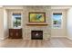 Living room features a stone fireplace and mantel, windows, and wood floors at 12168 Dorada Coast Ave, Las Vegas, NV 89138