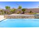 Close-up of the pool, featuring a cascading stone water feature and refreshing blue water at 12168 Dorada Coast Ave, Las Vegas, NV 89138