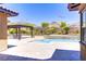 A stunning backyard oasis boasting a sparkling pool, spa, pergola, and lush desert landscaping at 12168 Dorada Coast Ave, Las Vegas, NV 89138