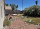 Backyard view with debris strewn across the property and a white flowering bush at 1409 Velvet Leaf Dr, North Las Vegas, NV 89032