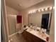 Bathroom featuring a double sink vanity with vanity lights and a shower with glass door at 1409 Velvet Leaf Dr, North Las Vegas, NV 89032