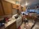 Kitchen featuring tile floor, oak cabinets, and significant clutter on the counters at 1409 Velvet Leaf Dr, North Las Vegas, NV 89032