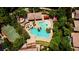 Aerial view of a community pool, waterpark, and playground surrounded by lush green trees and a basketball court at 1467 Melodic Lark Ln, Las Vegas, NV 89138