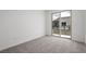 An unfurnished bedroom is carpeted with a sliding glass door and balcony at 1467 Melodic Lark Ln, Las Vegas, NV 89138