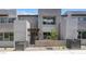 Modern townhouse featuring gray stucco, large windows, and a small landscaped front yard at 1467 Melodic Lark Ln, Las Vegas, NV 89138
