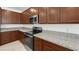 Modern kitchen with stainless steel appliances, granite countertops, and wood cabinetry at 1467 Melodic Lark Ln, Las Vegas, NV 89138
