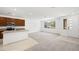Open floor plan featuring a kitchen with modern appliances and a large, carpeted living space at 1467 Melodic Lark Ln, Las Vegas, NV 89138