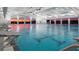 An indoor pool with diving boards and large windows, beautifully reflecting the evening sunset sky at 1467 Melodic Lark Ln, Las Vegas, NV 89138