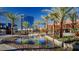 Scenic water feature reflecting palm trees and buildings under a clear blue sky in a modern urban landscape at 1467 Melodic Lark Ln, Las Vegas, NV 89138