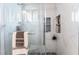 Elegant shower with glass door, marble tiles, rain shower head, and convenient shelving at 147 Cervantes St, Las Vegas, NV 89101