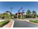 Elegant clubhouse entrance with flags, beautiful landscaping, and inviting architecture at 2244 Shadow Canyon Dr, Henderson, NV 89044