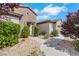 Close-up of the home's front entrance featuring a stone archway, desert landscaping, and manicured shrubbery at 2244 Shadow Canyon Dr, Henderson, NV 89044
