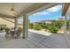 Relaxing covered patio with a ceiling fan, table, chairs, and a view of the landscaped backyard at 2244 Shadow Canyon Dr, Henderson, NV 89044