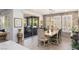 Chic dining area with unique chandelier, stone accent wall, and sliding door access to backyard at 25 Red Creek Bluff St, Henderson, NV 89011