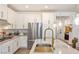 Modern kitchen features white cabinets, stainless steel appliances, and a stylish gold faucet at 25 Red Creek Bluff St, Henderson, NV 89011