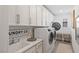 Bright laundry room featuring white cabinetry, modern washer and dryer, and stylish decor at 25 Red Creek Bluff St, Henderson, NV 89011