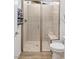 Close-up of a modern walk-in shower with gray and white tile, bench, and glass door at 25 Red Creek Bluff St, Henderson, NV 89011