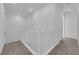 Bright hallway with carpet, white walls, and railing, leading to multiple rooms at 2536 Vandra St, Las Vegas, NV 89138