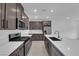 Modern kitchen with stainless steel appliances, quartz countertops, and dark cabinets at 2536 Vandra St, Las Vegas, NV 89138